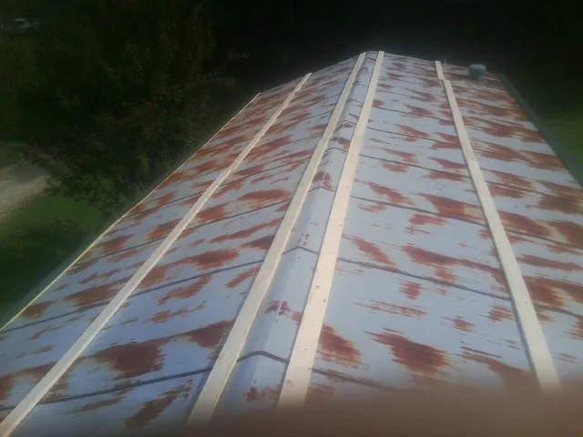 Rusted metal roof panels with new wood purlins before replacement — Storm Damage Roof Repair in Colquitt by Roofing Brothers